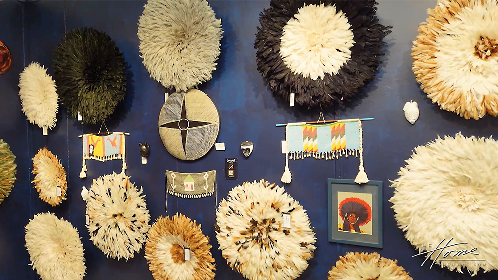 image of dark navy wall decorated with multiple colorful Juju hats made from chicken feathers