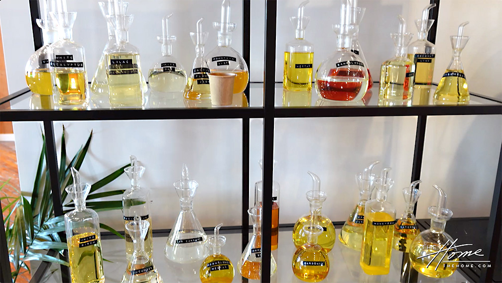 photo of 2 glass shelves with large clear bottles of fragrance on each shelf