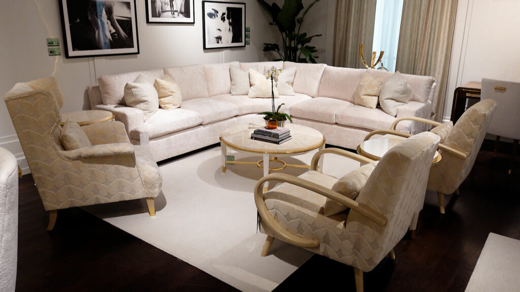 image of living room set with side chairs, cream color furniture, round coffee table on a cream color rug