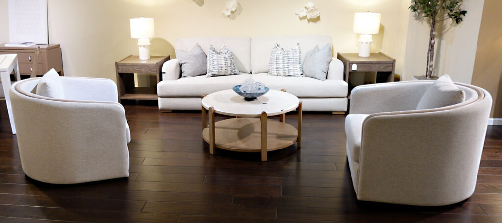 image of modern sofa and swivel chairs in modern design by Bernards Furniture, dark wood floor and round coffee table