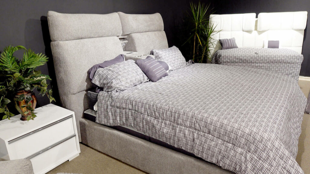 image of king size bed with gray headboard and white & black check bedding in showroom