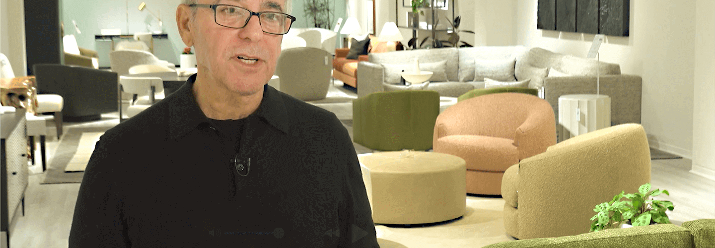 image of man in black shirt with glasses in front of modern iconic chairs and couches