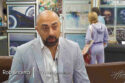 Image: man with dark beard and pinstripe suit jacket in front of wall of framed art prints. Text: Rob Sharma, CEO LDN Collections