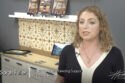 Image: woman in black and white dress in front of art tiles on backsplash in geometric yellow and brown pattern