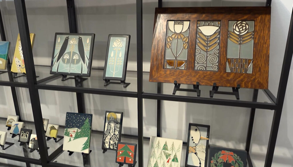 Image: shelves holding ceramic art tiles in Art Nouveau and Charley Harper art designs