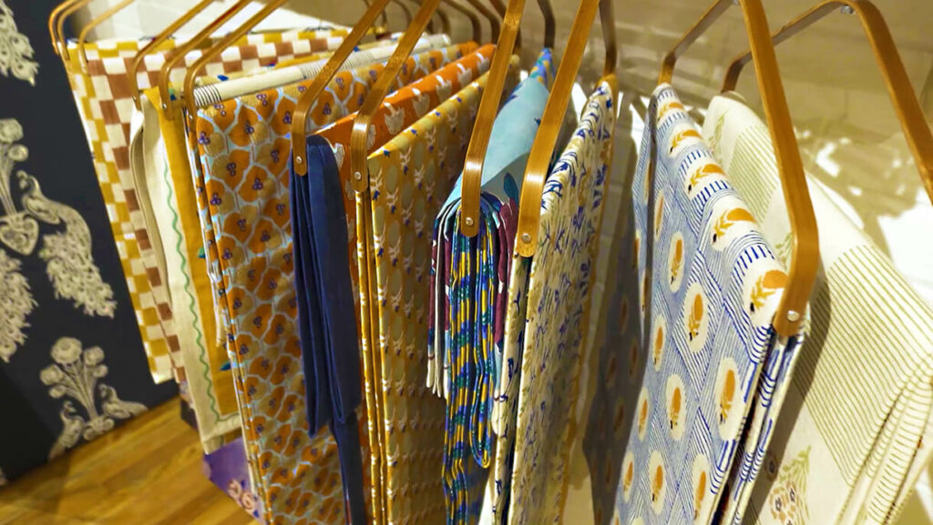 Image: colorful Indian traditional hand printed fabric on rack with wooden hangers