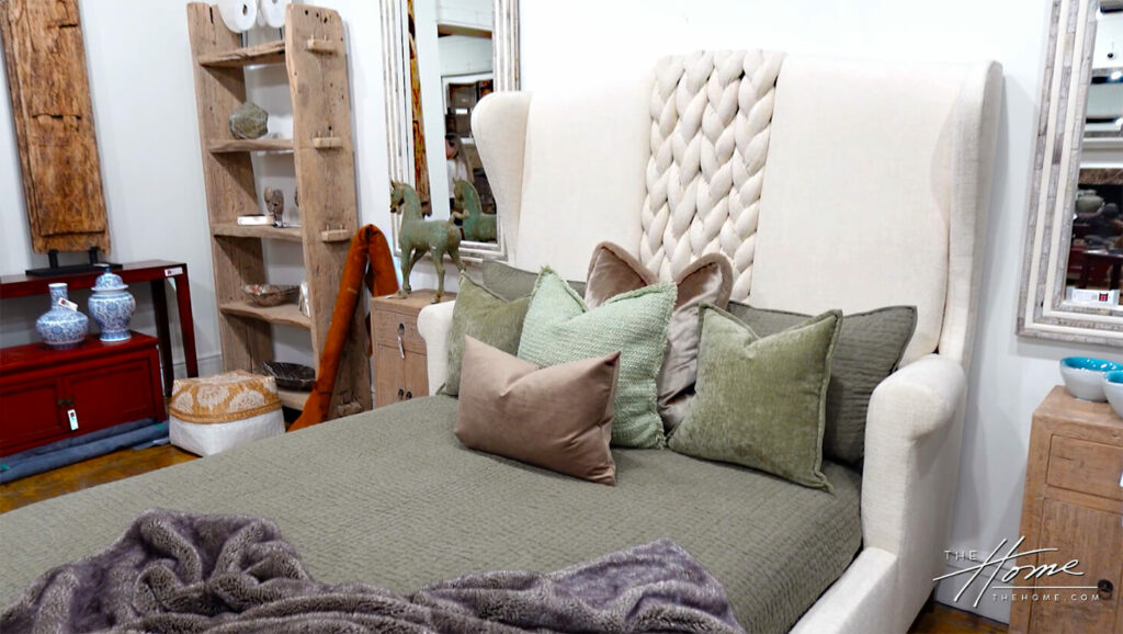 Image: gray quilt bed with upholstered white headboard and white braided section in a showroom of Victoria Lane Collection furniture